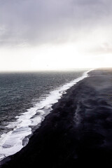 Black beach. Rocks in the water. Black stones in the ocean.