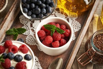 Fresh raspberries in a bowl, with flax seeds and oil, blueberries and cottage cheese