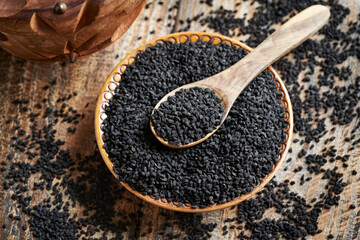 Black cumin or Nigella sativa seeds in a bowl and on a spoon