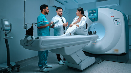 Neurologist doctor and nurse in uniform stand next to patient and explain procedure. Patient listening carefully to narration of medical staff. Medicine, healthcare and technology concept.