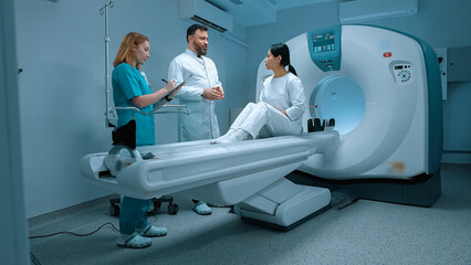 Doctor in white gown giving recommendations to patient after MRI. Patient lying at MRI capsule. MRI...