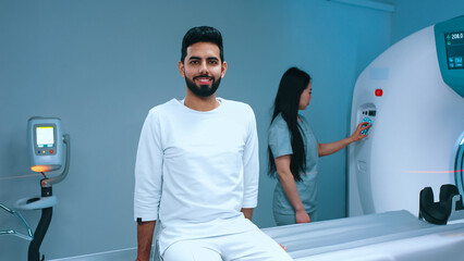 Muslim patient undergoing magnetic resonance tomography. Cheerful patient getting ready for...