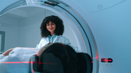 Medical laboratory radiologist controls MRI or CT or PET scan with patient undergoing procedure. Neurologist doctor conducts emergency checkup procedure with advanced medical technologies.