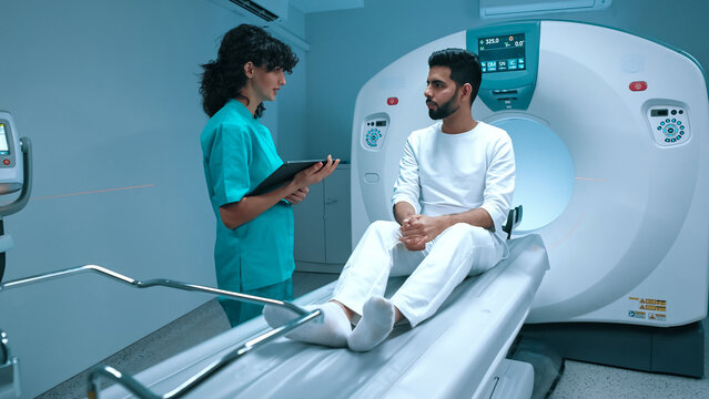 Positron emission tomography. Patient in modern clinic, listening doctor's explanation about X-ray examination of biopsy and method of healthcare. Medical facility's modern technology.