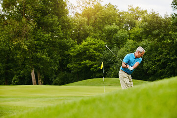 Old man, golf stroke and sports with retirement, weekend break and playing with grass field, active...
