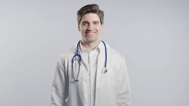 Doctor showing yes signal, nods head, approve. Positive agreed man on white