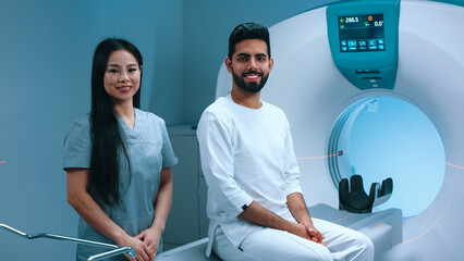 Satisfied doctor and patient looking at camera. Smiling Asian doctor and Indian patient. Patient...