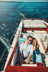 Couple, yacht and ocean for vacation, happy and outdoor with hug, above and travel in sunshine with romance. People, man and woman on cruise, water transport or adventure at sea for memory in Naples