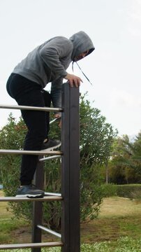 Man With Gray Hood Jumps And Does Somersault For Intensity Training