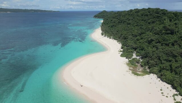 Captivating aerial capture of the Puka beach and turquoise sea on the north coast of Boracay island, Philippines. Flying backwards, panoramic view.
