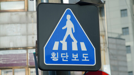 Pedestrian crossing traffic sign in Korea, text means crosswalk