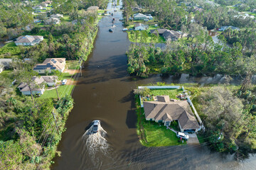 Hurricahe fainfall flooded Florida road with evacuating cars and surrounded with water houses in...