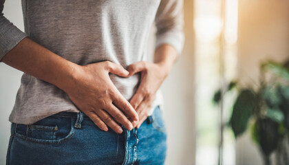 woman's hand gently holding her lower stomach, indicating discomfort or itching due to a skin disorder. The image focuses on the texture and detail of the skin
