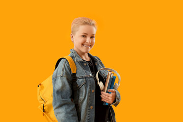 Female student with books and headphones on yellow background