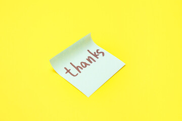Sticky note with word THANKS on yellow background