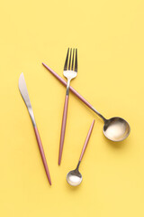 Stylish cutlery on yellow background