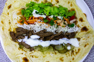 Traditional Shawarma sandwich fresh roll of, Grilled Meat and salad tortilla wrap with white sauce...