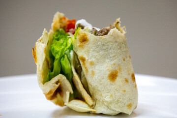 Traditional Shawarma sandwich fresh roll of, Grilled Meat and salad tortilla wrap with white sauce isolated on white background. Details