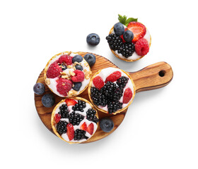 Wooden board of tasty tartlets with whipped cream and berries on white background
