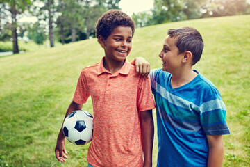 Soccer ball, friends and children in park with smile, bonding and games on outdoor holiday together. Sports, nature and happy kids on grass with support, fun and diversity on summer camp for football