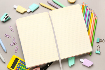 Notebook with different stationery supplies on grey background