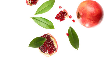 Flying fresh pomegranates with seeds and leaves on white background