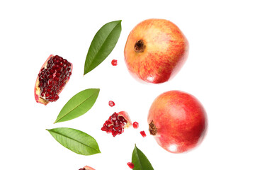Flying fresh pomegranates with seeds and leaves on white background