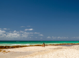 mujer meditando en la playa sentada en la arena