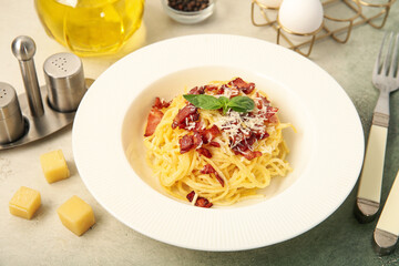 Plate with tasty pasta carbonara on light background