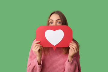 Beautiful young woman with heart like icon on green background