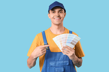 Young painter with color palettes on blue background
