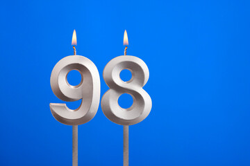 Birthday candle number 98 - Celebration card on blue background