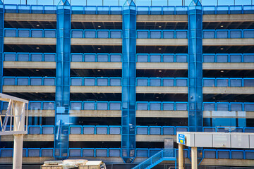 Multilevel Parking Garage with Blue Glass Elevator and Pedestrian Bridge