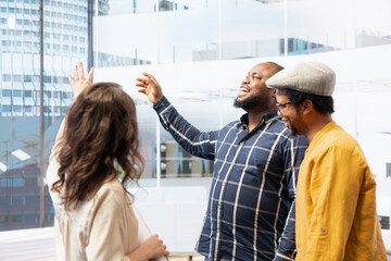 Clients and realtor touring a new high class office space and reviewing layout blueprints for...