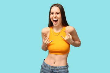 Beautiful young happy woman with piercing navel on blue background