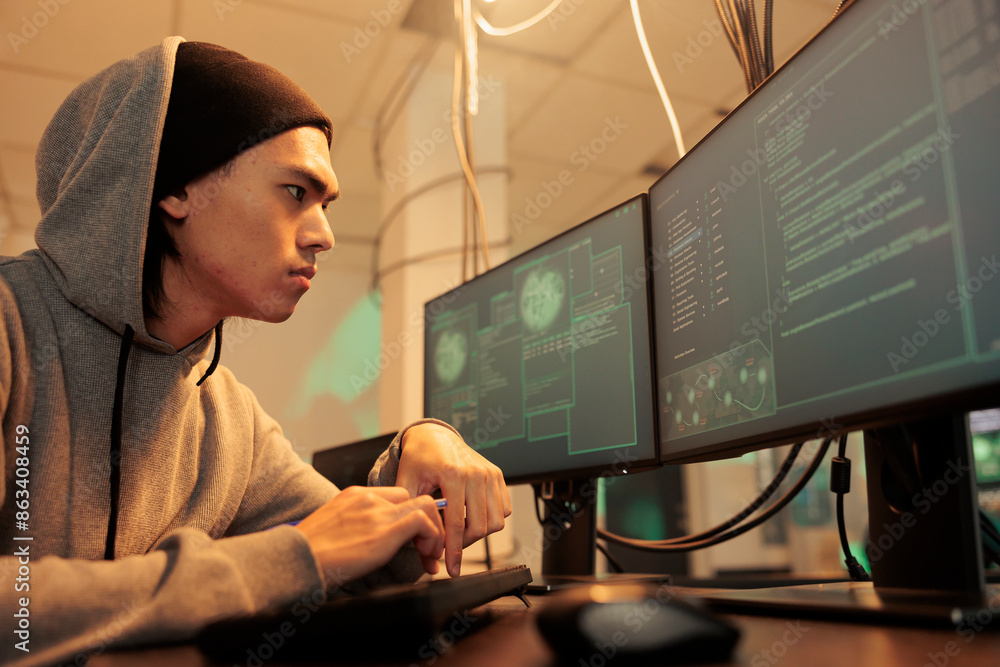 Poster male hacker trying to break into government network, coding computer virus on database late at night