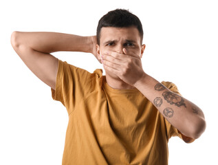 Handsome young man feeling bad smell from armpits on white background