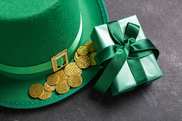 Gift box with leprechaun hat and golden coins for St. Patrick's Day celebration on black grunge...