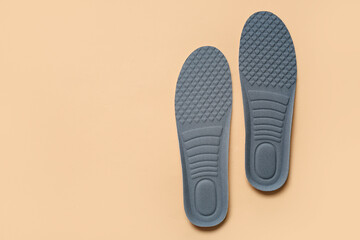 Grey orthopedic insoles on beige background