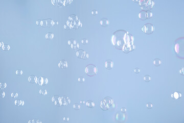 Beautiful transparent soap bubbles on light grey background