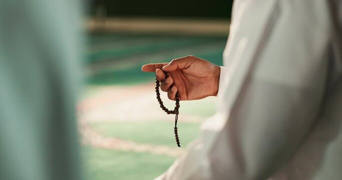 Muslim, person or hands with beads in Mosque for peace, counting or gratitude to Allah in holy temple. Tasbih, Islamic or spiritual ritual for praying to worship God on Ramadan Kareem in Saudi Arabia