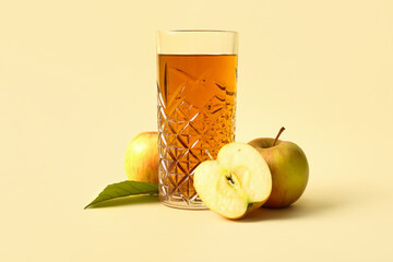Glass of fresh apple juice on yellow background