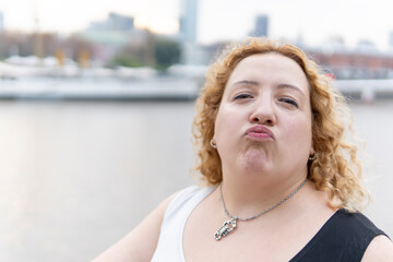 Fototapeta premium Close-up portrait of plus size blonde woman blowing a kiss