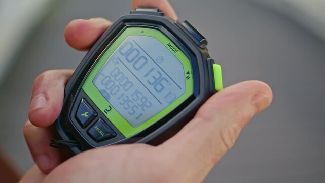 Hand pressing sport timer on race competition. Closeup man holding stopwatch