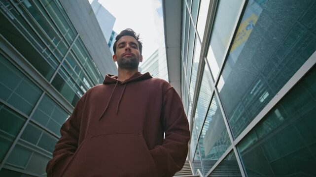 City explorer looking camera at contemporary buildings. Closeup urban man walk