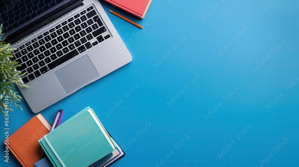 Leinwandbilder a laptop and textbooks are placed on a blue desk, symbolizing the combination of traditional and dig