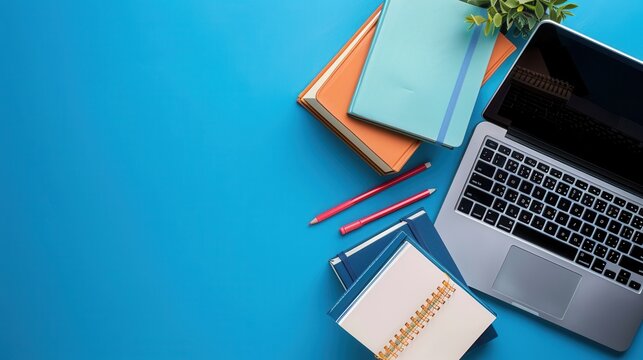 A laptop, textbooks, and pencils lay on a blue desk, showcasing contemporary learning methods. Generative AI