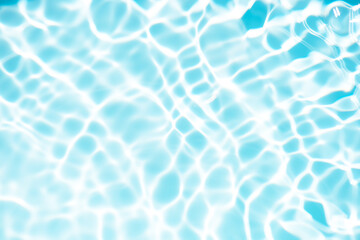 Blue water with ripples on the surface. Defocus blurred transparent blue colored clear calm water surface texture with splashes and bubbles. Water waves with shining pattern texture background.