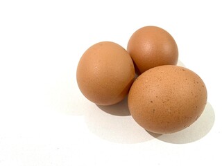 Three fresh and raw chicken brown eggs isolated on white background
