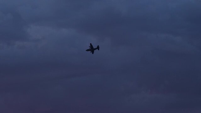 夕方の空に飛んでいる自衛隊のC-130空中輸送機の姿